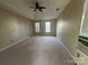Bright bedroom featuring a tray ceiling, fan, and multiple windows for natural light and ventilation at 3898 Longwood Sw Dr, Concord, NC 28027