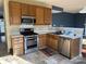 Efficient kitchen design with stainless steel appliances, wood cabinets, and a view into the adjacent living area at 3898 Longwood Sw Dr, Concord, NC 28027
