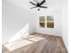 Sunlit bedroom featuring modern floors, a ceiling fan, and views of the surrounding trees at 424 Airline Ave, Shelby, NC 28150