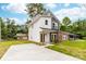 View of a two-story home with modern gray and white exterior and a freshly paved concrete driveway at 424 Airline Ave, Shelby, NC 28150