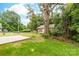 View of a grassy yard in the back of a home featuring sparse landscape and partial tree coverage at 424 Airline Ave, Shelby, NC 28150