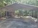 Large metal carport provides ample covered parking and storage with an adjacent shed in the wooded area at 4409 Homestead Rd, Rock Hill, SC 29732