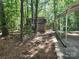Wooden shed among mature trees and vegetation with an adjacent metal carport structure at 4409 Homestead Rd, Rock Hill, SC 29732