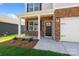 Inviting front entrance with stone accents, covered porch, manicured landscaping, and a 2-car garage at 4623 Harris Elliot Rd, Lincolnton, NC 28092