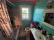 Bathroom includes a tub/shower combination, window, single sink vanity, and plenty of storage at 506 Sycamore Ave, Gastonia, NC 28052