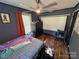 This cozy bedroom includes a ceiling fan, window, projector screen and unique wood-look flooring at 506 Sycamore Ave, Gastonia, NC 28052