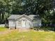 Quaint single story home with a gabled roof, set against a backdrop of lush green trees at 506 Sycamore Ave, Gastonia, NC 28052