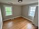 Empty bedroom features beautiful hardwood floors and two windows that allow for natural light to fill the room at 520 Margaret Dr, Statesville, NC 28677