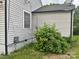 Angled corner of the house with gray vinyl siding, window, and a covered satellite dish at 520 Margaret Dr, Statesville, NC 28677