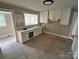 An empty kitchen awaiting appliances, featuring white cabinets, a large window, and tile flooring at 520 Margaret Dr, Statesville, NC 28677