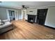 A sunlit living room with hardwood floors, a decorative fireplace, and blue trim along the ceiling at 520 Margaret Dr, Statesville, NC 28677
