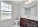 Bathroom features a large window, a dark wood vanity, and neutral decor at 5305 Friendly Baptist Church Rd, Indian Trail, NC 28079