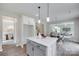 Kitchen island with seating overlooks the open floor plan with a dining area, stairway, and living room at 5305 Friendly Baptist Church Rd, Indian Trail, NC 28079