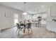 Open concept kitchen with a dining area, featuring stainless steel appliances and bright white cabinets at 5305 Friendly Baptist Church Rd, Indian Trail, NC 28079