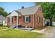 A charming brick house has black shutters, a red door, and an attached covered area at 604 Meadowbrook Rd, Kings Mountain, NC 28086