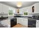 Well-lit kitchen featuring white cabinetry, black appliances, and natural light at 604 Meadowbrook Rd, Kings Mountain, NC 28086