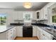 Bright kitchen with white cabinets, black countertops, and modern appliances at 604 Meadowbrook Rd, Kings Mountain, NC 28086