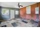 Unique living room with brick accent wall, gray walls, ceiling fan and patchwork style flooring at 604 Meadowbrook Rd, Kings Mountain, NC 28086