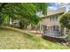 Backyard featuring a deck, siding, trampoline, and sloped landscaping at 6434 Skyline Dr, Charlotte, NC 28269