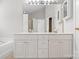 Bathroom with dual sink vanity, framed mirrors, and cabinet storage at 6434 Skyline Dr, Charlotte, NC 28269