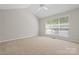 Bright bedroom featuring vaulted ceiling, neutral carpet, and large window at 6434 Skyline Dr, Charlotte, NC 28269