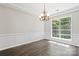Elegant dining room with hardwood floors, wainscoting, crown molding, and modern lighting at 6434 Skyline Dr, Charlotte, NC 28269