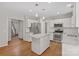 Open kitchen boasting an island, white cabinets, stainless appliances, and hardwood floors at 6434 Skyline Dr, Charlotte, NC 28269