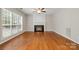 Cozy living room with fireplace, large window, and ceiling fan at 6434 Skyline Dr, Charlotte, NC 28269