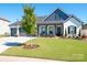 Inviting home with well-kept lawn, charming porch, and Craftsman-style details at 7112 Irongate Dr, Indian Land, SC 29707