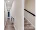 Hallway with hardwood floors, carpeted stairs, and a sliding barn door at 7112 Irongate Dr, Indian Land, SC 29707