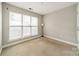 Bright, carpeted bedroom with three large windows allowing ample natural light to flow into the room at 738 Garden District Dr, Charlotte, NC 28202