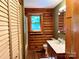 Bathroom featuring wood paneled walls, sink with vanity, toilet, shower, and framed mirror at 8464 Robinson Church Rd, Charlotte, NC 28215