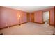 Bedroom featuring wood trim, neutral carpet, and access to the ensuite bathroom at 8464 Robinson Church Rd, Charlotte, NC 28215