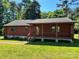 Charming log cabin with a covered front porch, stone accents, and a lush green lawn at 8464 Robinson Church Rd, Charlotte, NC 28215
