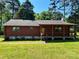 Charming log cabin with a covered front porch, stone accents, and a lush green lawn at 8464 Robinson Church Rd, Charlotte, NC 28215