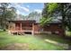 Charming log cabin with a covered porch, well-maintained lawn, and mature trees creates a peaceful setting at 8464 Robinson Church Rd, Charlotte, NC 28215
