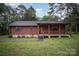 Charming log cabin with stone accents and a cozy front porch nestled among mature trees at 8464 Robinson Church Rd, Charlotte, NC 28215