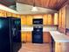 Efficient kitchen with wood cabinets, laminate counters, and black appliances at 8464 Robinson Church Rd, Charlotte, NC 28215