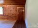 Cozy living room features wood walls, hardwood floors and a lovely front door at 8464 Robinson Church Rd, Charlotte, NC 28215