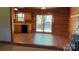 Open living space with wood paneled walls, and a kitchen area visible through doorway at 8464 Robinson Church Rd, Charlotte, NC 28215