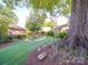 Tranquil backyard with a mature tree, beautiful landscaping, and a well-maintained lawn at 907 Edgewood Cir, Gastonia, NC 28052
