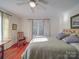 Sunlit bedroom with hardwood floors, a ceiling fan, natural light, and neutral walls, complete with decorative curtains at 907 Edgewood Cir, Gastonia, NC 28052