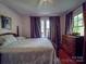Bedroom featuring a wooden bed frame, hardwood floors, and natural light from windows at 907 Edgewood Cir, Gastonia, NC 28052