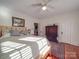 Light-filled bedroom featuring hardwood floors, a ceiling fan, and neutral walls, alongside a decorative wooden cabinet at 907 Edgewood Cir, Gastonia, NC 28052