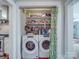 Conveniently located laundry room features a washer, dryer, storage shelves, and a curtain at 907 Edgewood Cir, Gastonia, NC 28052
