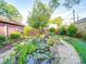 Scenic backyard pond with lush vegetation, smooth river stone and a natural rock border at 907 Edgewood Cir, Gastonia, NC 28052