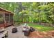 Backyard with stone patio, firepit, outdoor seating, and wooded views at 9217 Tenby Ln, Matthews, NC 28104