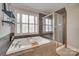 Bright bathroom with a large tub, separate glass shower, and built-in shelving at 9217 Tenby Ln, Matthews, NC 28104