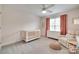 Cozy Bedroom with crib, comfortable armchair, accent pouf, and neutral-toned decor at 9217 Tenby Ln, Matthews, NC 28104