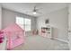 Bright bedroom featuring plush carpeting, a ceiling fan, and a pink play tent for children at 9217 Tenby Ln, Matthews, NC 28104